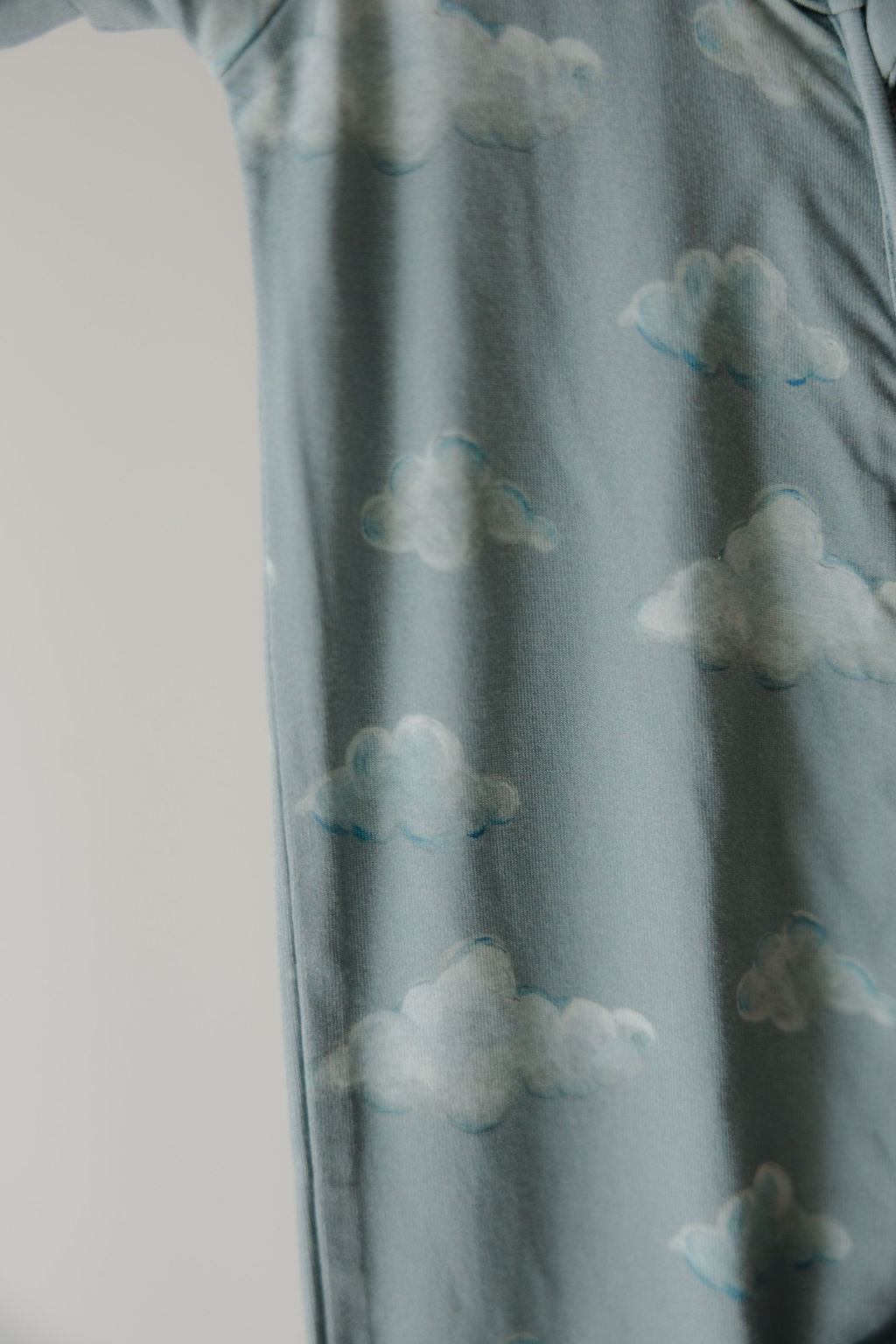 A close-up of light blue fabric patterned with white clouds from the Kendy 3 Bamboo Zip Shortie | Duke—soft, slightly textured bamboo material that's hypo-allergenic and ideal for sensitive skin.