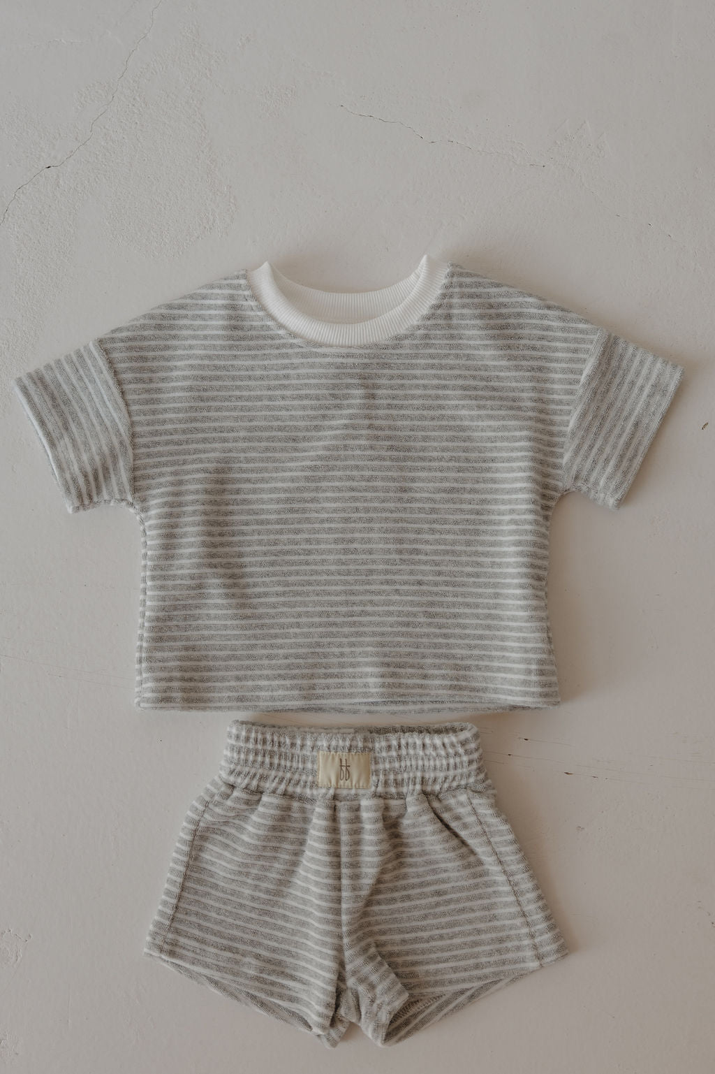 The forever french baby Child Terry Short Set in Grey Stripe includes a short-sleeved shirt and shorts, shown laid flat—ideal for cherishing family moments.