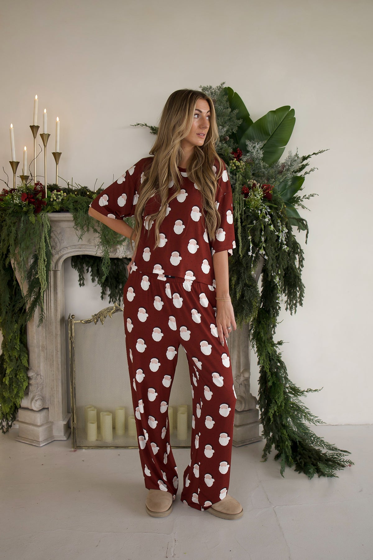 A woman wearing a burgundy Women’s Boxy Tee Lounge Set | Vintage Santa with a repeating white print, featuring a short-sleeved top and matching wide-leg pants.