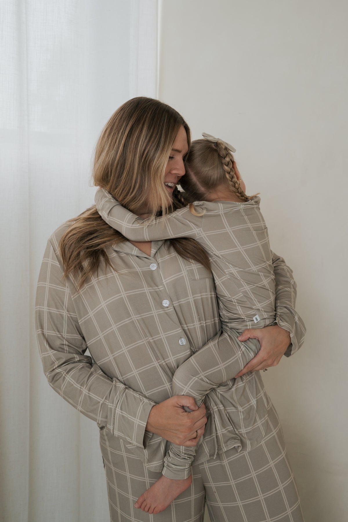 A woman and a young girl wearing matching Bamboo Two Piece Pajamas | Linen Grid with a white grid pattern.