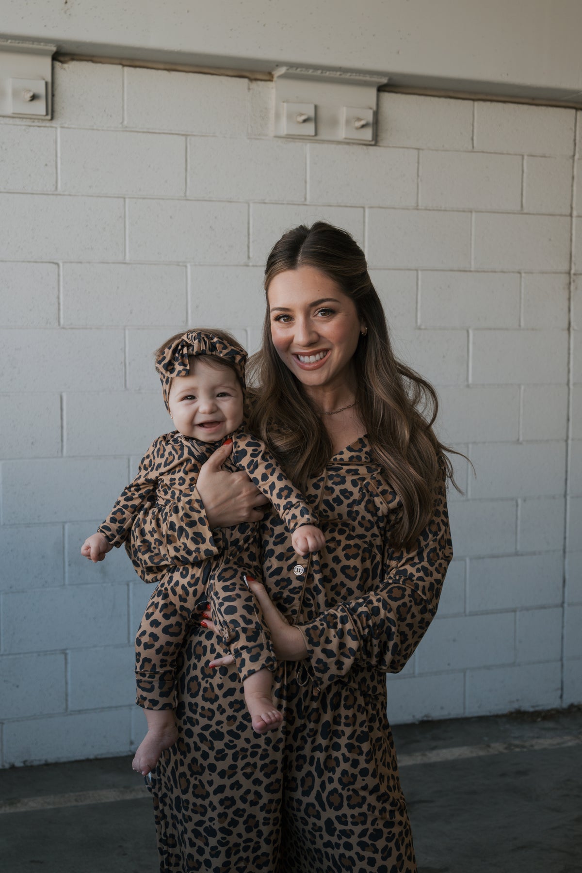A woman and baby wearing matching leopard-print Women’s Bamboo Button Up Lounge Set | Leopard outfits pose together.