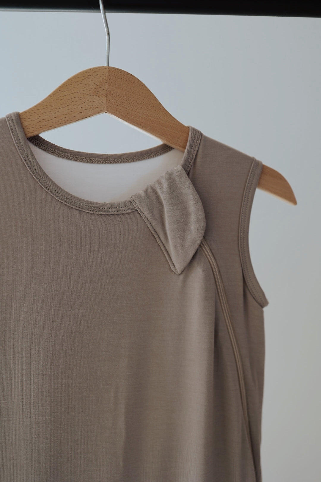 The Bamboo Sleep Sack in grey from forever french baby is shown on a wooden hanger against a plain background, capturing the cozy simplicity and comfort reminiscent of its soft, sleeveless design.