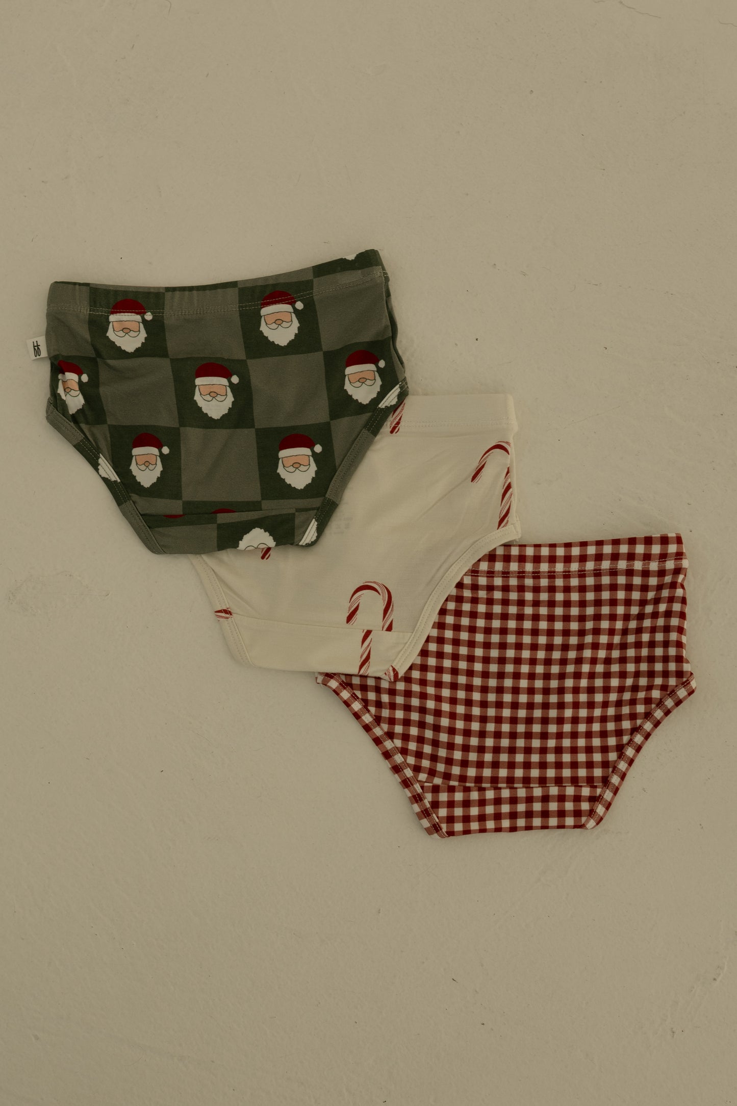 The forever french baby Girl's Bamboo Briefs (3 Pack) includes red gingham, candy cane, and Santa checkerboard designs. Made from soft, hypo-allergenic bamboo for girls.
