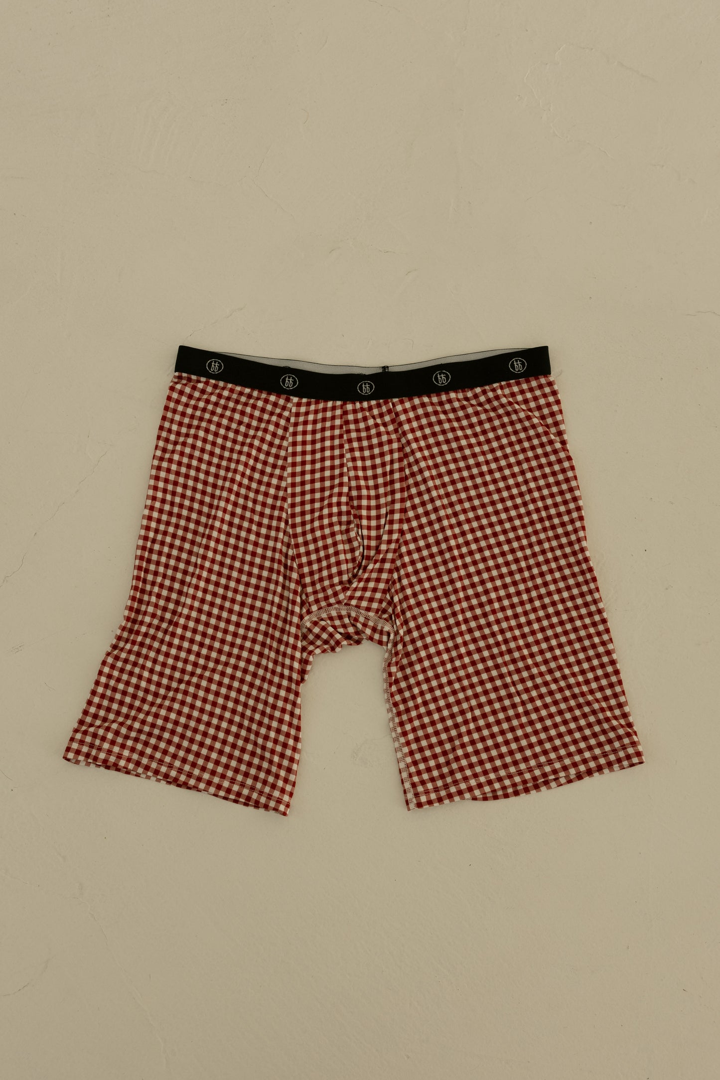 Forever french baby Men's Bamboo Boxers (3 Pack) in Red Gingham, Candy Cane & Santa Checkerboard feature a black waistband with a white pattern and are made from breathable bamboo fabric, shown flat on a light beige surface.