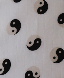 A close-up of a white fabric with a repeating Yin-Yang pattern. The Yin-Yang symbols alternate between black and beige, each featuring a contrasting dot within the teardrop shapes of the symbol. The texture indicates soft muslin cotton, perfect for the Muslin Crib Sheet | Black & Ivory Yin Yang by forever french baby.