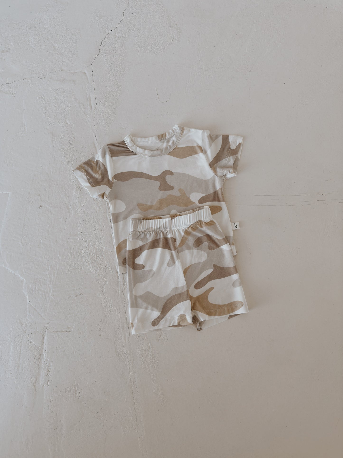 The Bamboo Short Set | Camo 2.0 by forever french baby, a breathable beige and white camo T-shirt and shorts set for toddlers, is displayed flat on a textured off-white surface.