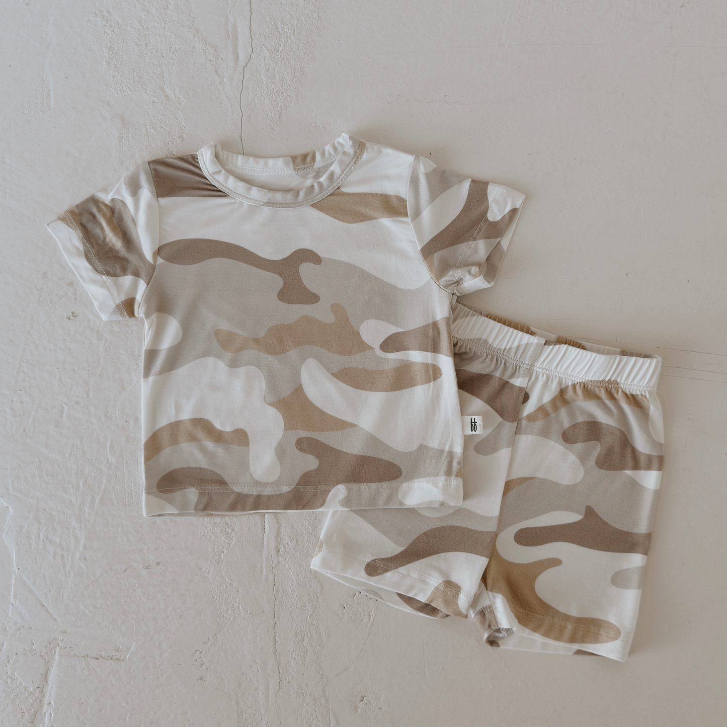 The forever french baby Bamboo Short Set | Camo 2.0 features a beige, brown, and white camo print in breathable fabric for all-day comfort, displayed flat on a light textured surface.