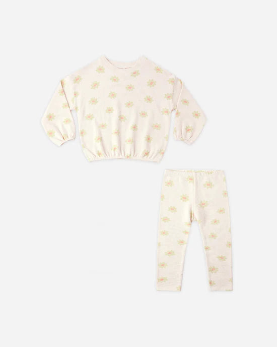 The Rylee + Cru Spongey Knit Set | Yellow Daisy is a cozy, cream-colored children’s pajama set featuring long sleeves and pants, both adorned with a delicate pastel yellow daisy print. Laid flat on a white background, this charming set offers comfort and style reminiscent of your favorite toddler sweatshirt and leggings.