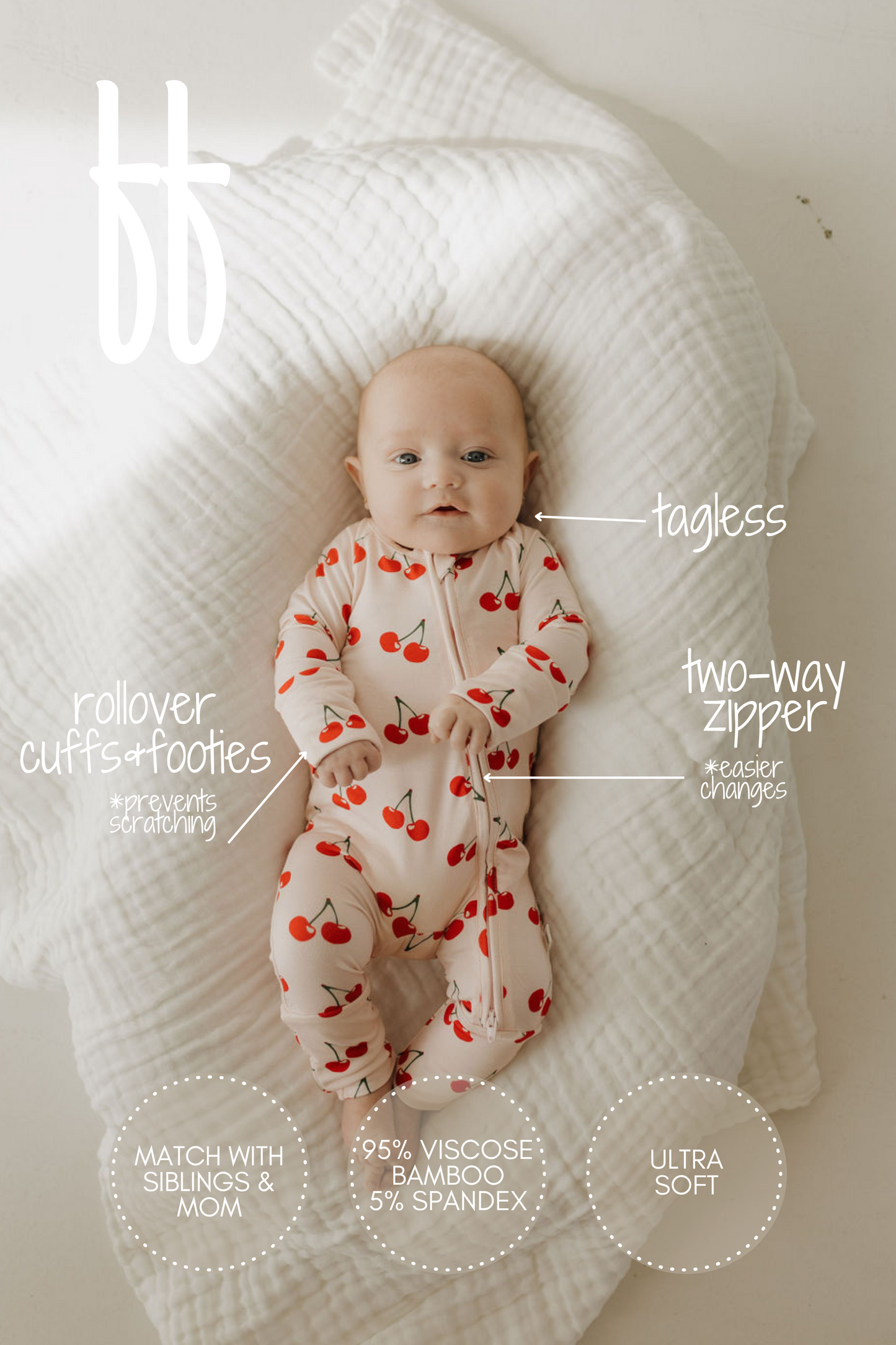 A baby rests on a white blanket in forever french baby's Bamboo Zip Pajamas | Cherry Orchard onesie, featuring red cherries, hypo-allergenic tagless design, two-way zipper for easy changes, rollover cuffs, footies, and ultra-soft fabric. Matching sibling and mom options are available.