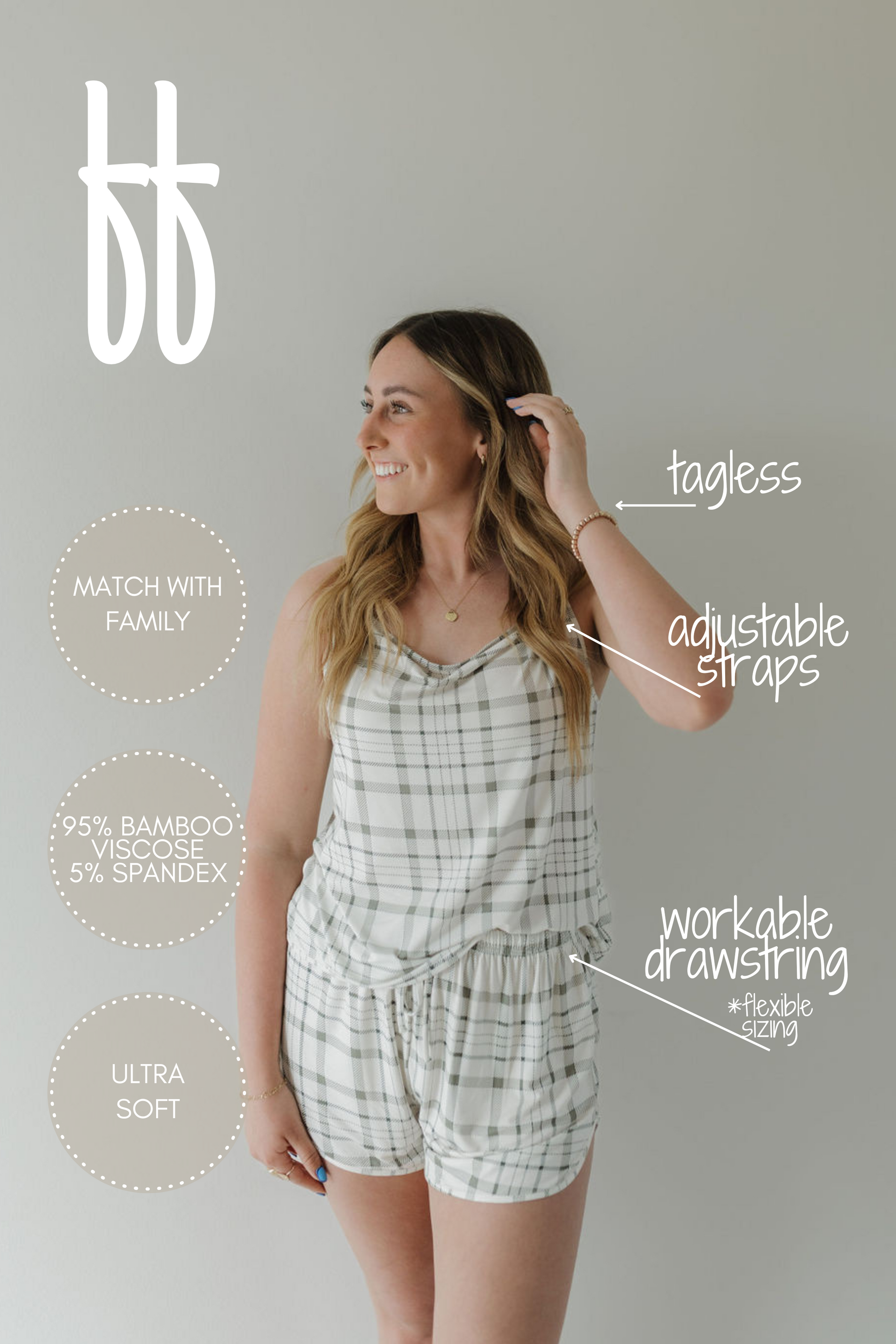 A woman in the Cami Women's Bamboo Set | Picnic Plaid by forever french baby smiles to the side. This set features a sleeveless plaid top and adjustable strap shorts made of breathable, hypo-allergenic bamboo. Her long hair flows freely, complemented by minimal jewelry—perfect for matching family outfits.