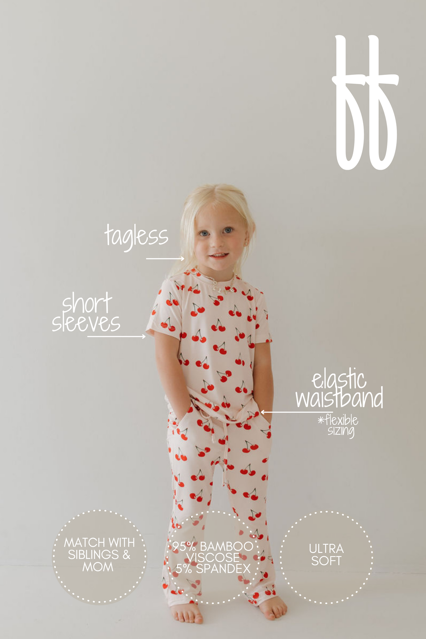 A young child wears the Toddler Short Sleeve Bamboo Lounge Set | Cherry Orchard by forever french baby, featuring tagless, short sleeves, and an elastic waistband. Made with 95% bamboo viscose and 5% spandex, this ultra-soft, hypo-allergenic fabric offers matching options for ultimate comfort.