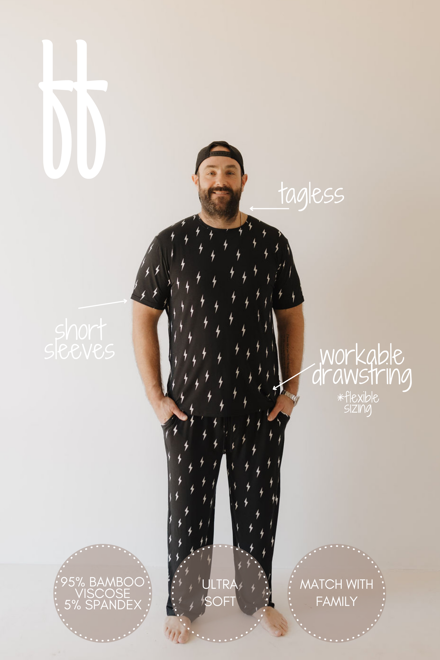 A person in Men's Bamboo Short Sleeve Pajamas by forever french baby, featuring a black and white lightning bolt design, stands against a light background. The tagless top pairs with drawstring pants, crafted from 95% bamboo viscose and 5% spandex for breathable, hypoallergenic comfort.