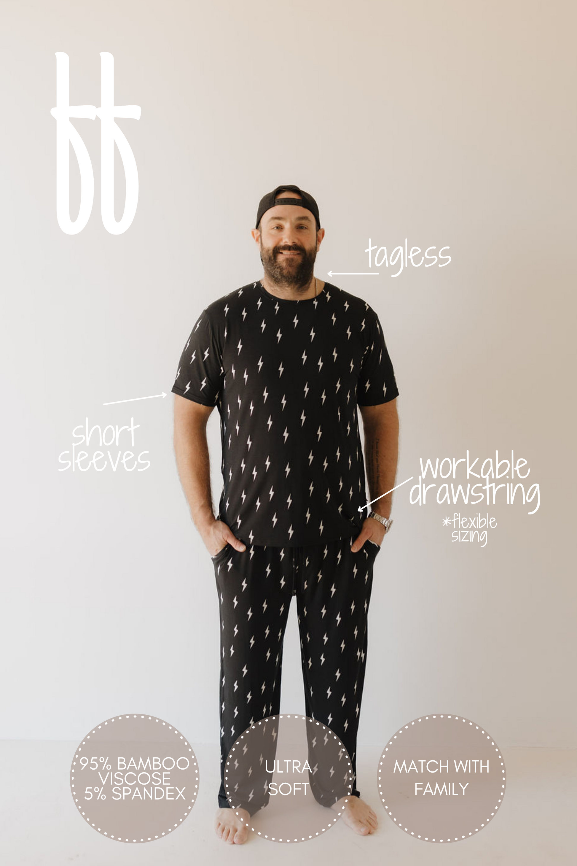 A person in Men's Bamboo Short Sleeve Pajamas by forever french baby, featuring a black and white lightning bolt design, stands against a light background. The tagless top pairs with drawstring pants, crafted from 95% bamboo viscose and 5% spandex for breathable, hypoallergenic comfort.