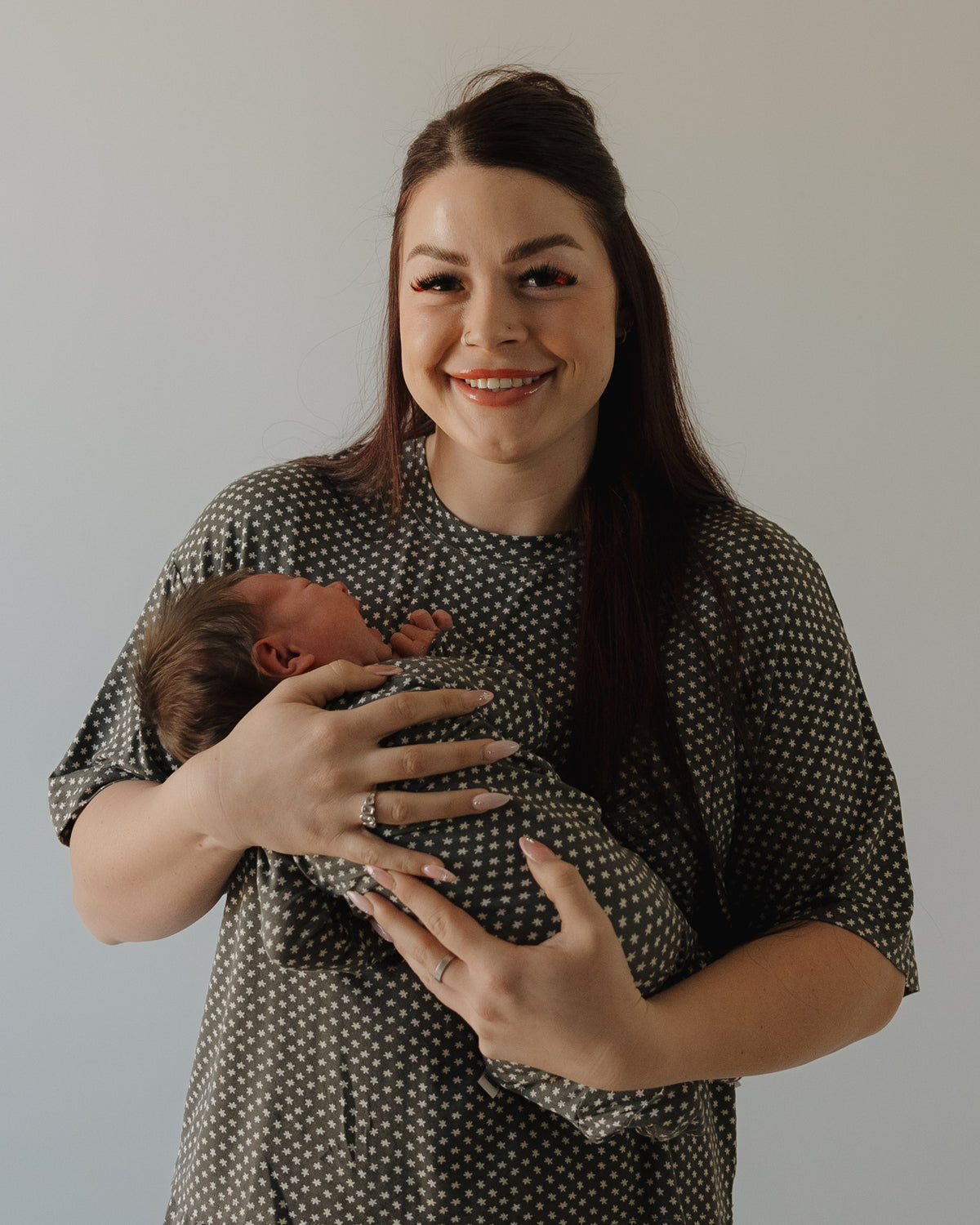 A woman holds her baby, both radiating comfort and coziness in forever french baby's Women's Boxy Tee Lounge Set | Green Flowers.