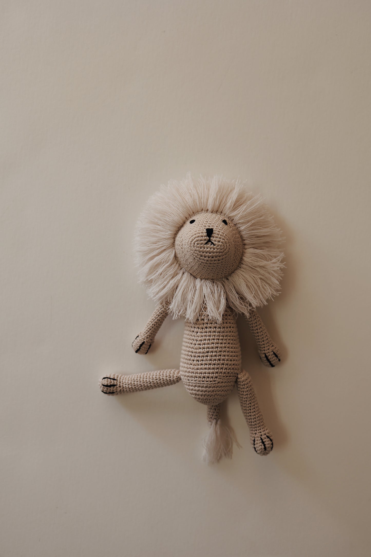 Forever French Baby introduces Lennon the Lion, a knit doll with a beige body and a fluffy, majestic mane, set against a plain, light background. The lion features simple embroidered facial details and black-tipped limbs, exuding both charm and elegance.