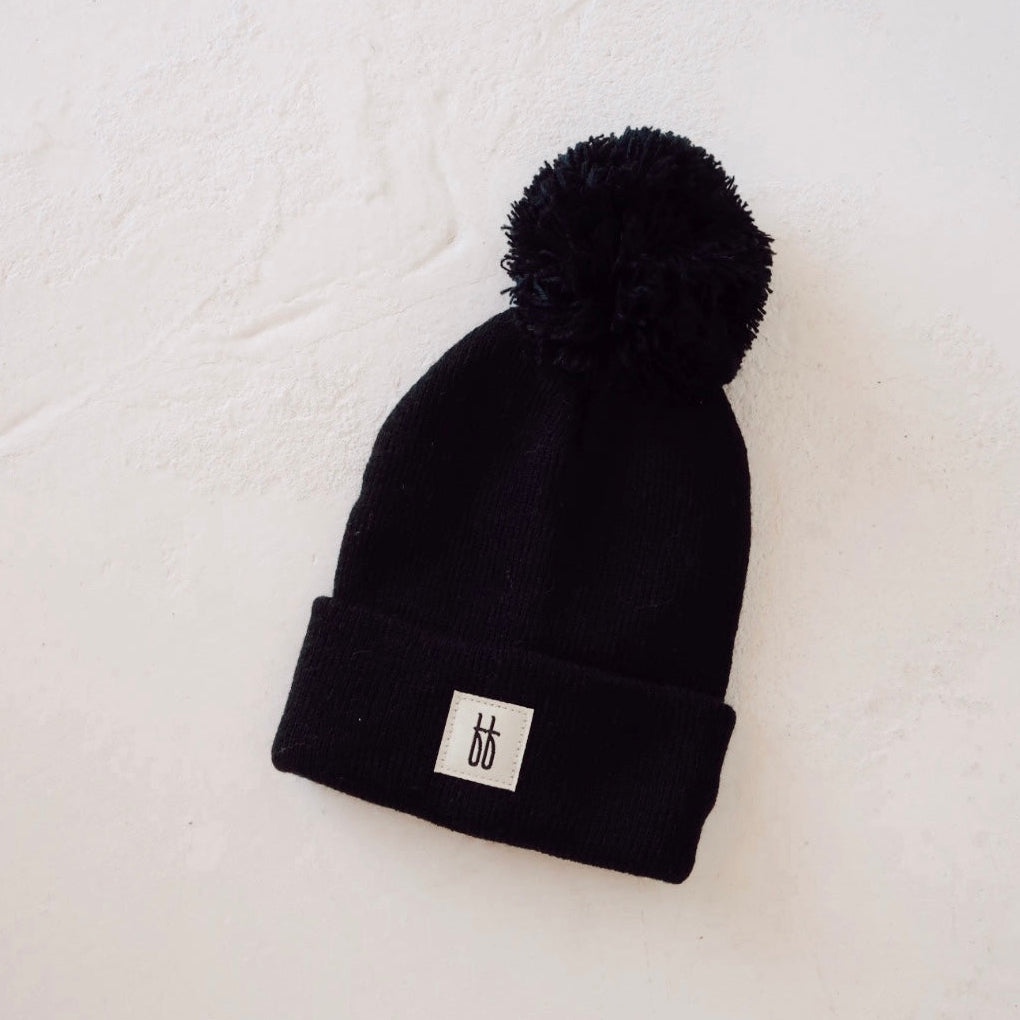 A black and gray plaid cap with a small "bb" logo on the front, placed on a light, neutral surface.