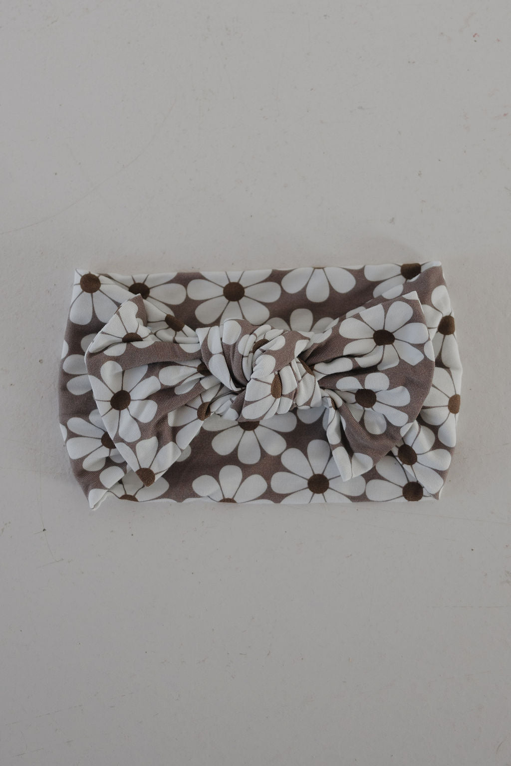 The Bamboo Head Wrap | Darlin' by forever french baby features a white daisy pattern on gray with a large bow knot, shown on a light surface.