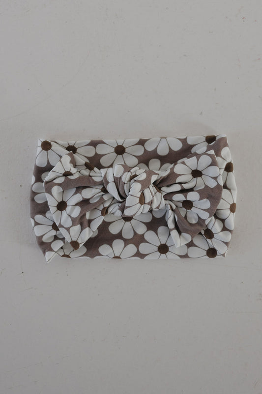The Bamboo Head Wrap | Darlin' by forever french baby features a white daisy pattern on gray with a large bow knot, shown on a light surface.