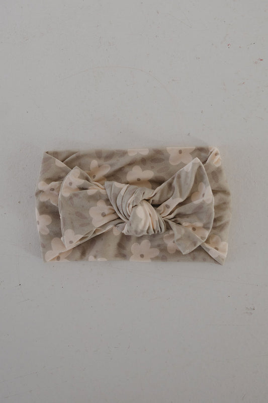 The forever french baby Bamboo Head Wrap | French Gray Floral is a soft, light gray bamboo headband with a large knotted bow and white flower pattern, shown laid flat on a plain light surface.