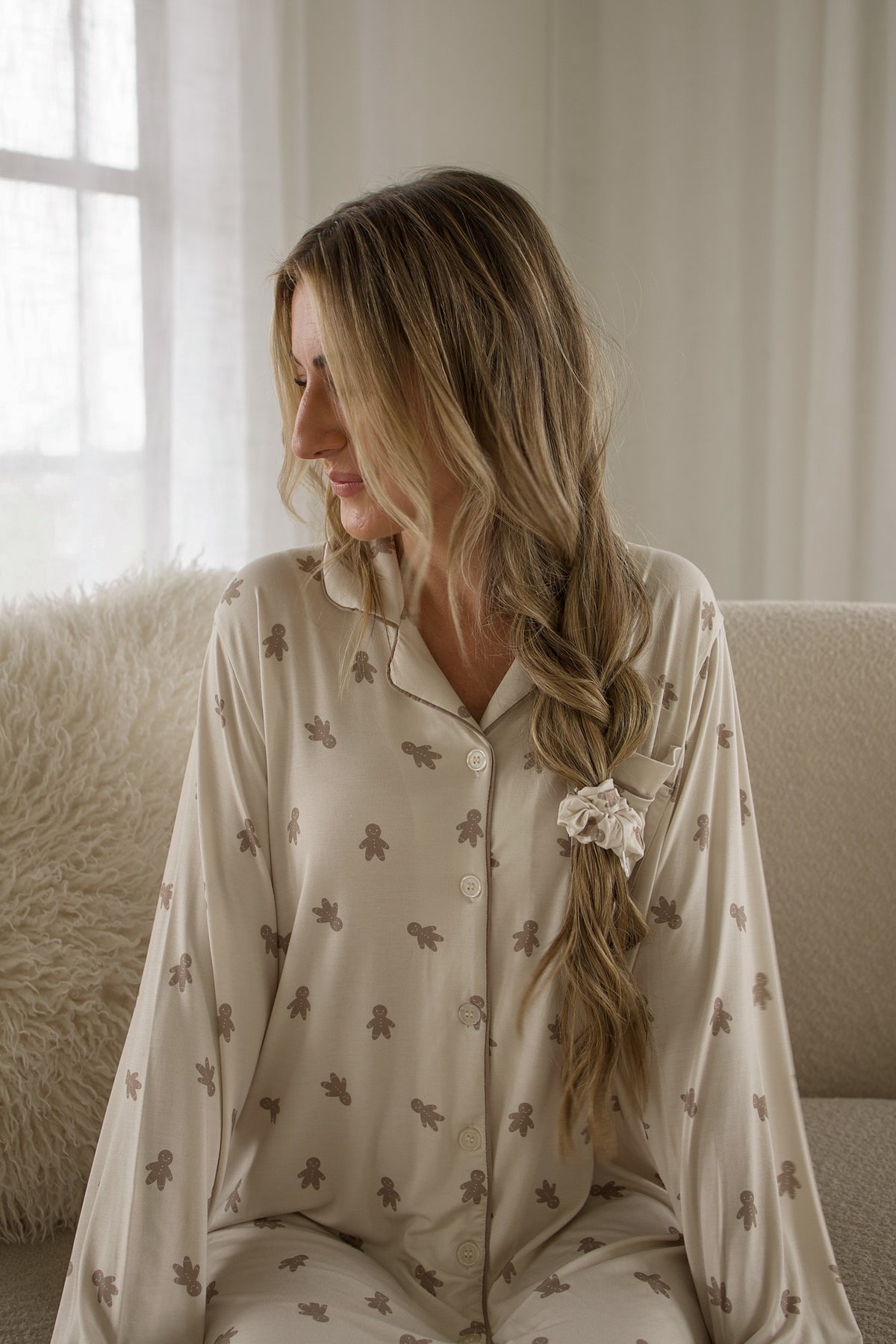 A woman wearing a Women’s Bamboo Sleeping Dress | Gingersnap long-sleeved top patterned with small gingerbread men.