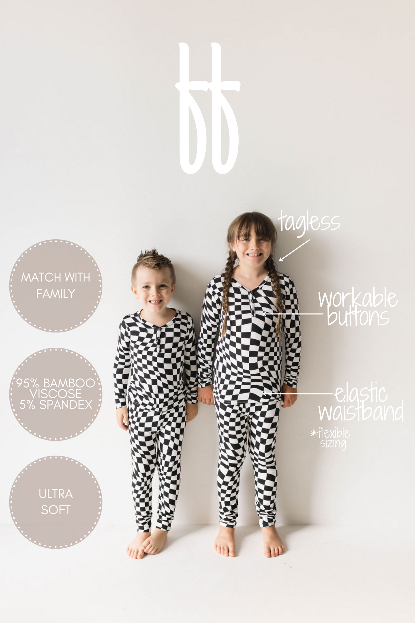 Two children are standing side by side, clad in Black & White Wavy Checkerboard Bamboo Two Piece Pajamas from forever french baby. Made of 95% bamboo viscose and 5% spandex, these ultra-soft, tagless pajamas feature a workable button front and an elastic waistband. With flexible sizing and hypo-allergenic properties, they offer both comfort and style.