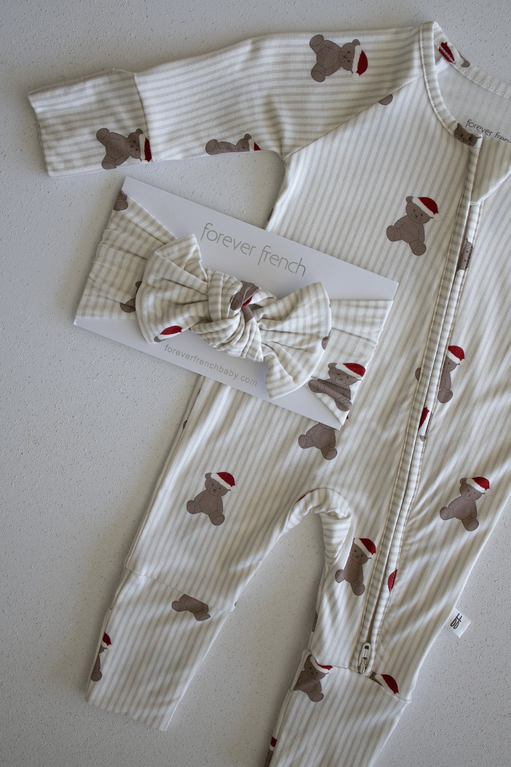 Bamboo Head Wrap | Santa Teddy by forever french baby, paired with a striped baby onesie featuring brown Santa Teddy bears in red hats, displayed on a "forever french" card atop a light surface.