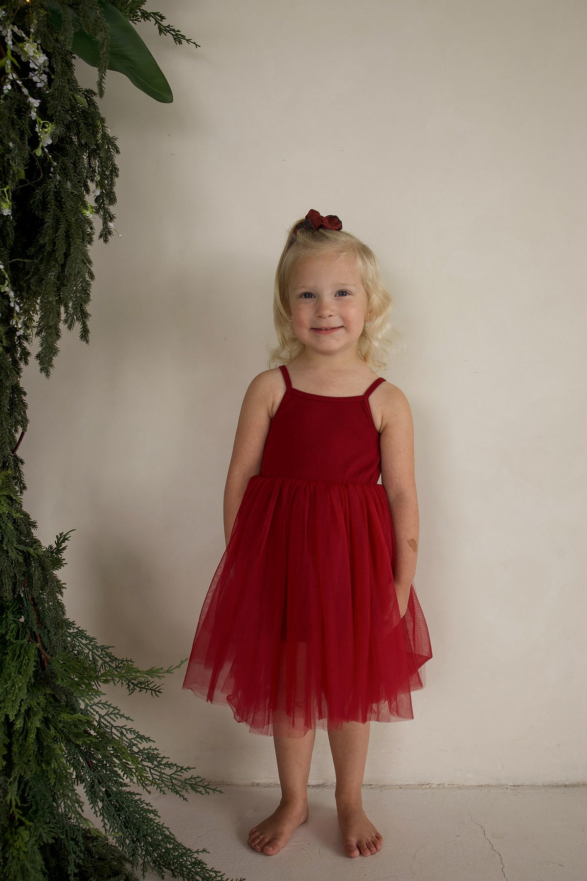 A young child wears a cranberry-red ff Tutu Dress featuring a ribbed top and a full, layered tulle skirt.