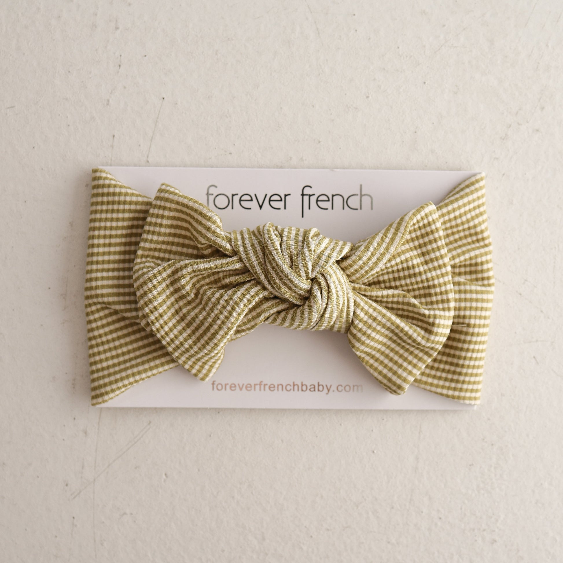 A Bamboo Head Wrap in Willow Stripe Ribbed by forever french baby is shown on a white card with “forever french” and “foreverfrenchbaby.com” printed below, against a light, textured background.