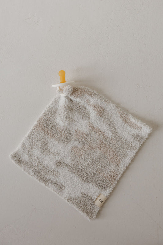 The forever french baby Lovey | Camo 2.0 is a soft, square microfiber plush with a neutral camo pattern and an attached pacifier, perfect for comfort and security.