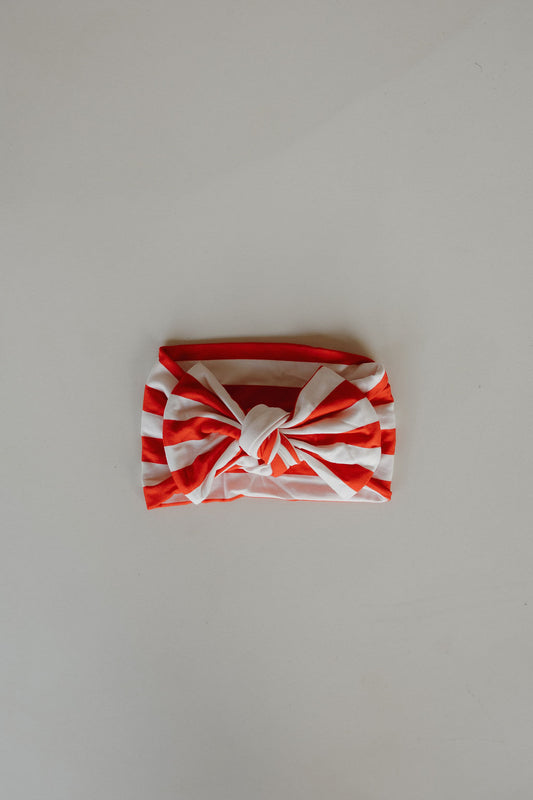 The forever french baby Bamboo Head Wrap | Stripes features red and white stripes with a center knot, displayed flat on a light surface.