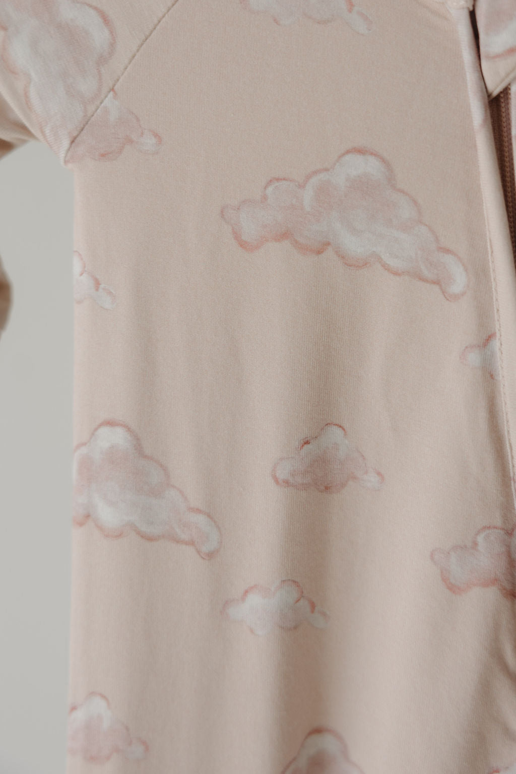 Close-up of the Kendy 3 Bamboo Zip Shortie | Ruby shows light beige fabric with soft, pink-outlined clouds, creating a whimsical look. The premium bamboo material offers breathable comfort—ideal for cozy nights or stylish lounging.