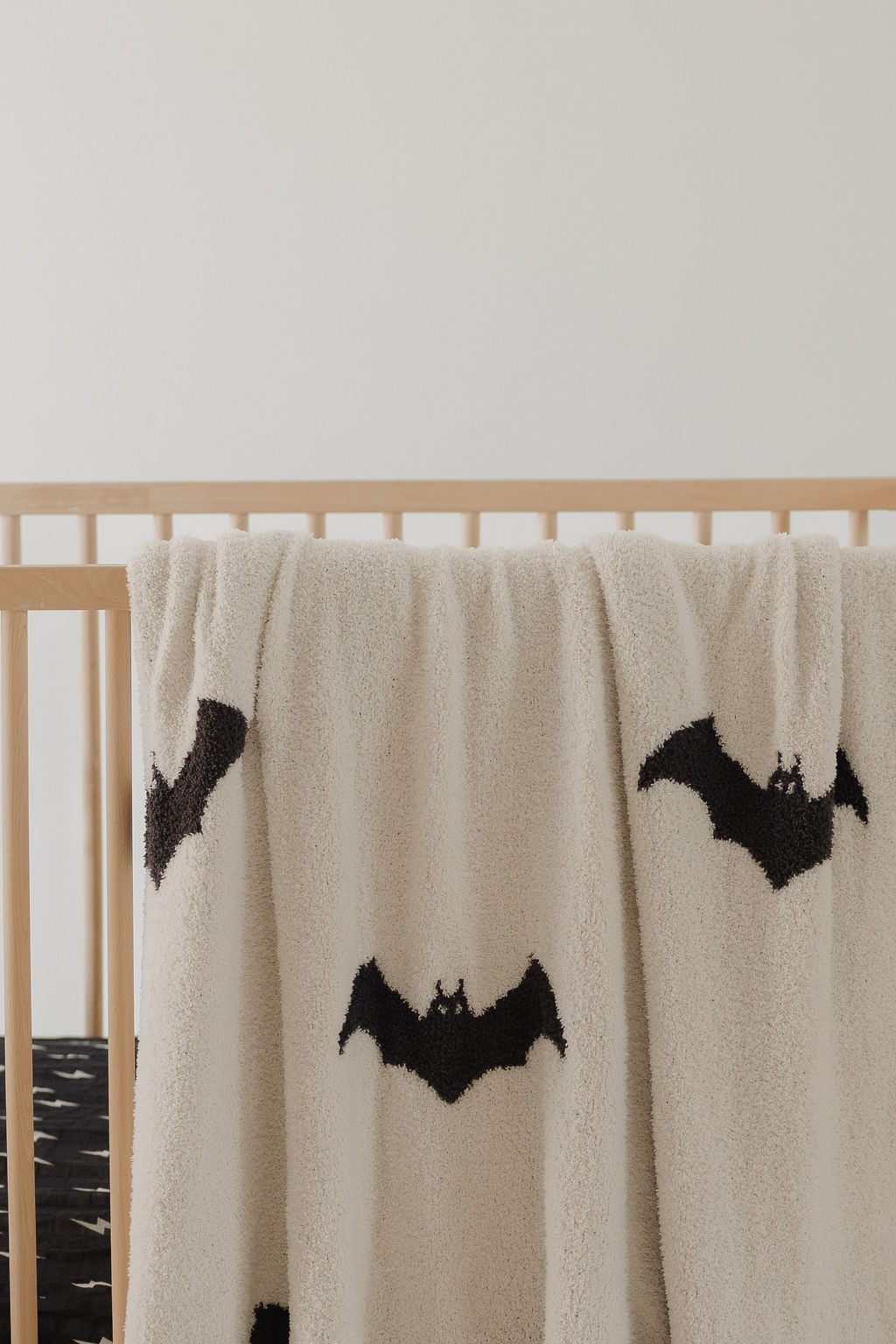The forever french baby Plush Blanket | It's Bats! features a beige, fluffy microfiber design with black bat silhouettes, OEKO-TEX certified for safe, cozy comfort in your baby's crib.