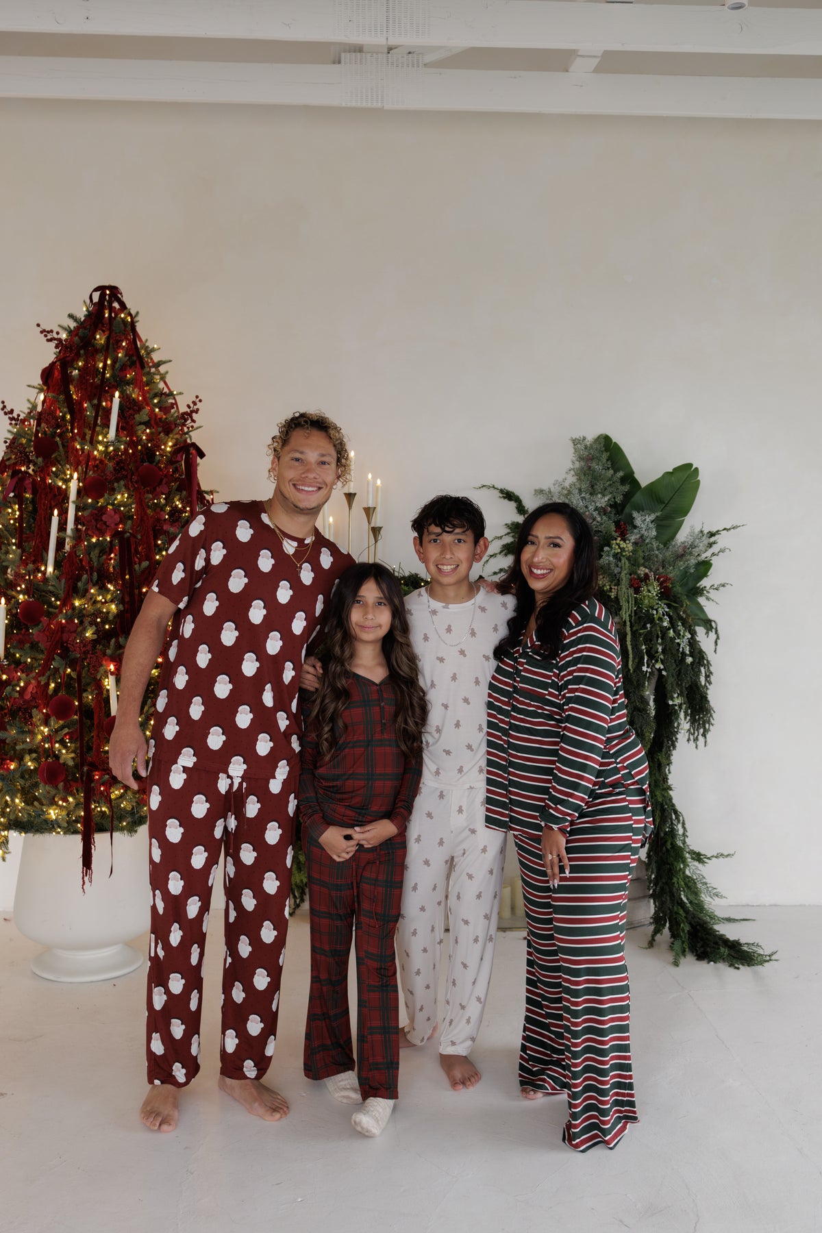 A family of four stands in front of a Christmas tree wearing matching Men’s Short Sleeve Pajamas | Vintage Santa by forever french baby.