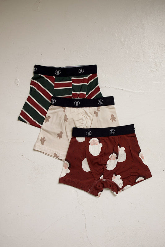 Bamboo Boxers (3 Pack) | Holiday ’26 featuring three pairs of hypoallergenic bamboo boxer briefs with patterns of red and green stripes, gingerbread men, and Santa Claus faces.