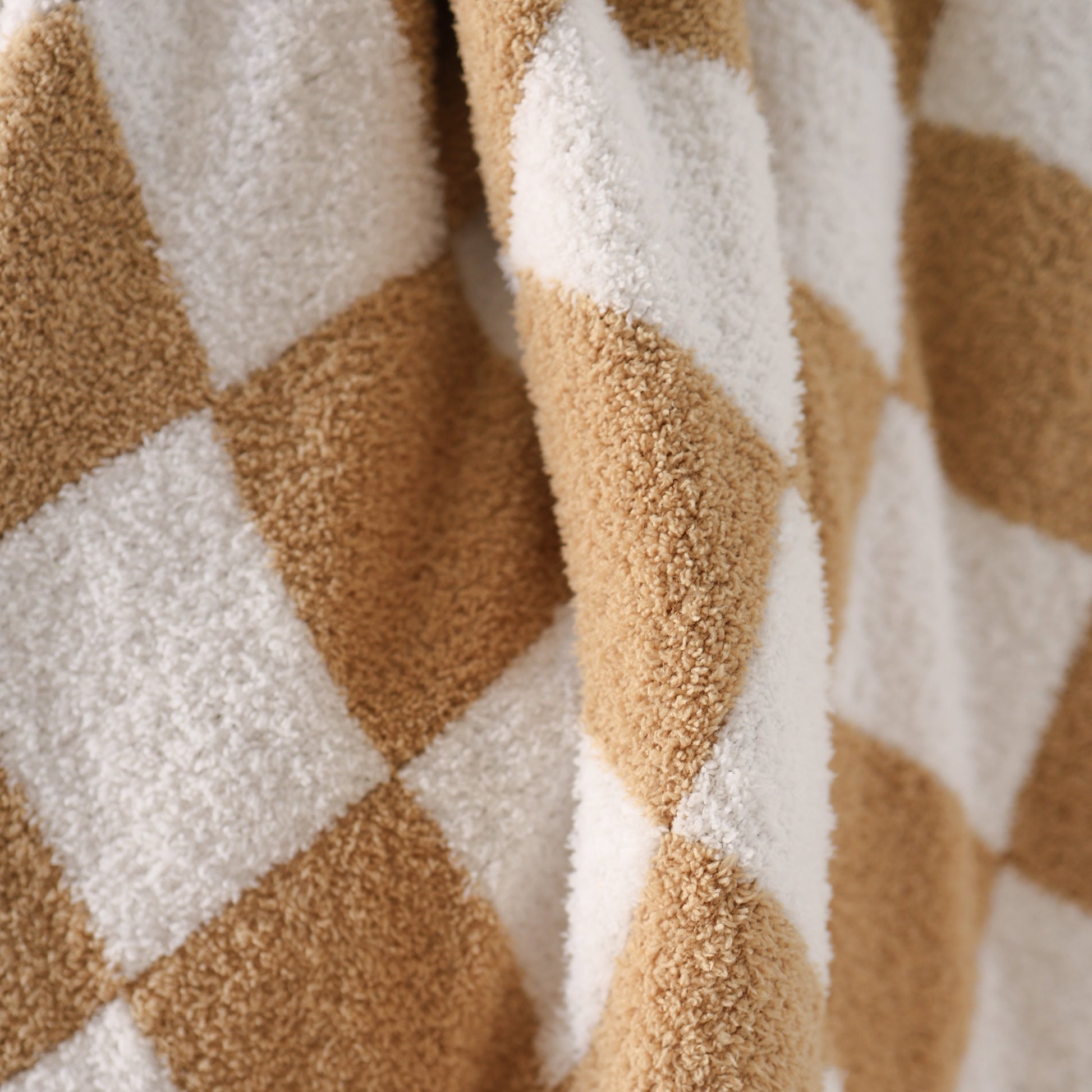 Close-up of the forever french baby Plush Blanket | Original Checkerboard, showcasing its soft microfiber fabric with a brown and white checkerboard pattern, plush raised squares, and gentle folds.