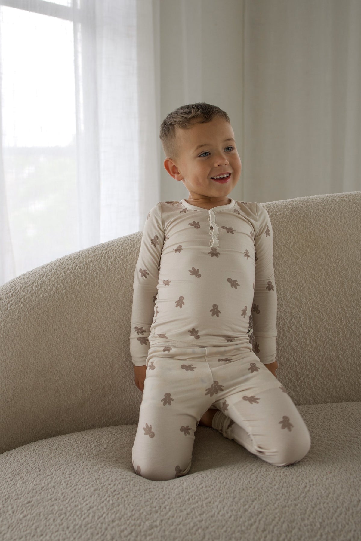 A toddler wearing Bamboo Two Piece Pajamas | Gingersnap kneels on a couch.
