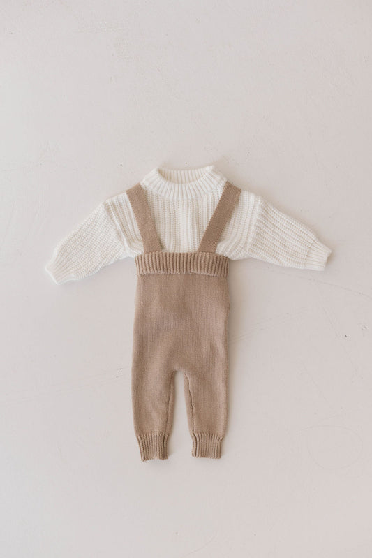 A wonderful addition to your little one's wardrobe, this outfit showcases the Knit Sweater | Cloud, a white long-sleeved knit sweater from forever french baby, paired with light brown knitted overalls with suspenders. The overalls feature ribbed cuffs and extend down to the ankles. This Forever Free set is displayed laid flat against a light, neutral background.