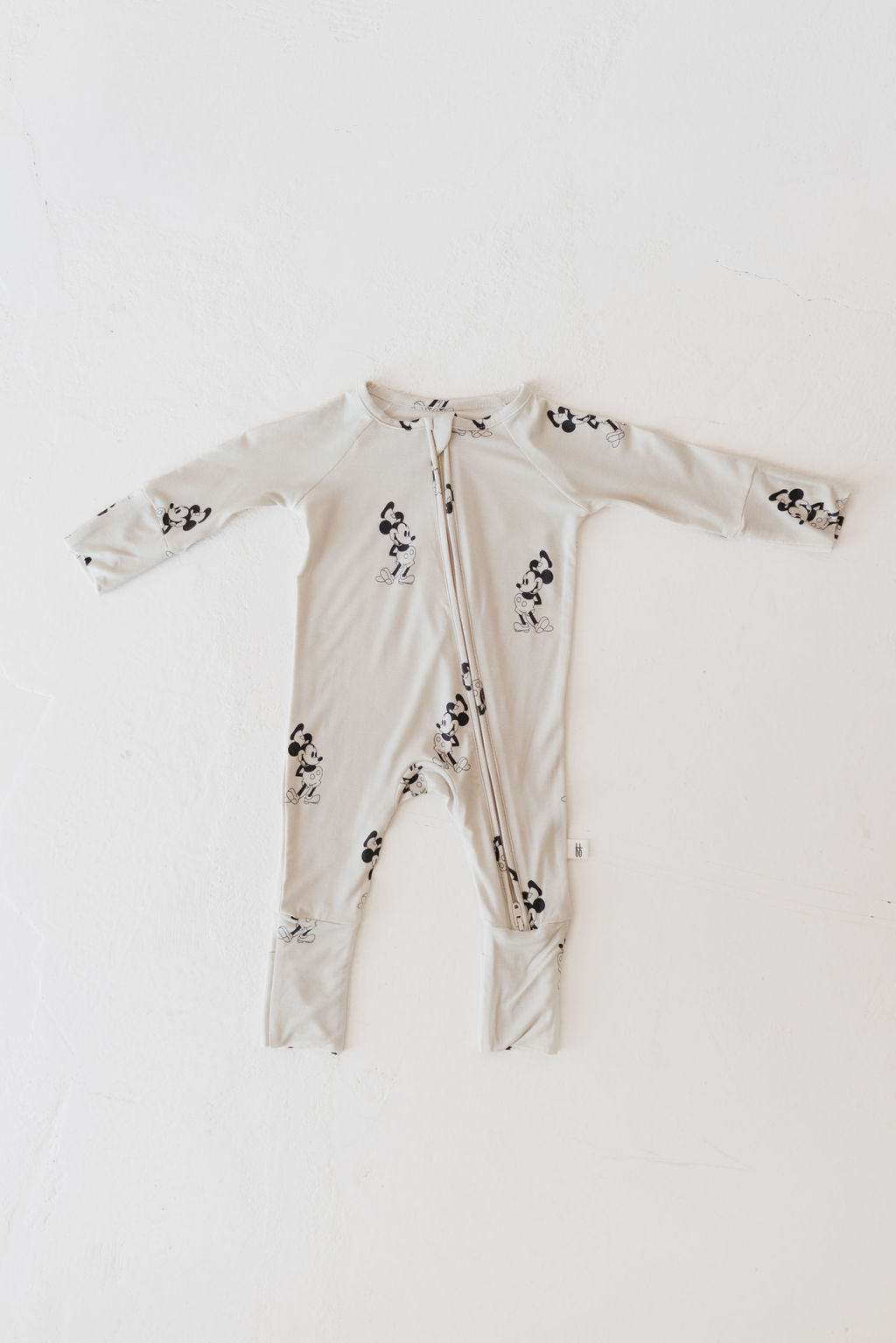 The "All Aboard!" Bamboo Zip Pajamas by forever french baby are light gray baby onesies crafted from breathable bamboo fabric, showcasing a black and white cartoon mouse design. They come with long sleeves, footed legs, and a front zipper, laid flat against a white background.