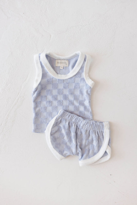 A two-piece children's outfit in a periwinkle blue checker print, featuring a sleeveless tank and matching shorts. The comfortable, stylish set is perfect for keeping kids cool and looking trendy.