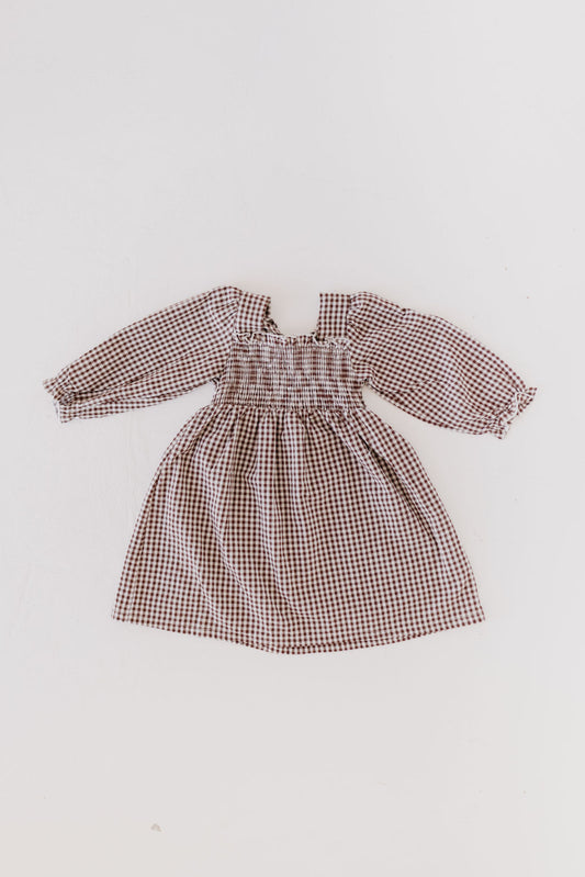 The "Child Long Sleeve Dress | Chocolate Chai" by forever french baby, featuring a checkered print and shirred bodice, is displayed flat on a white background. Perfect for babies.