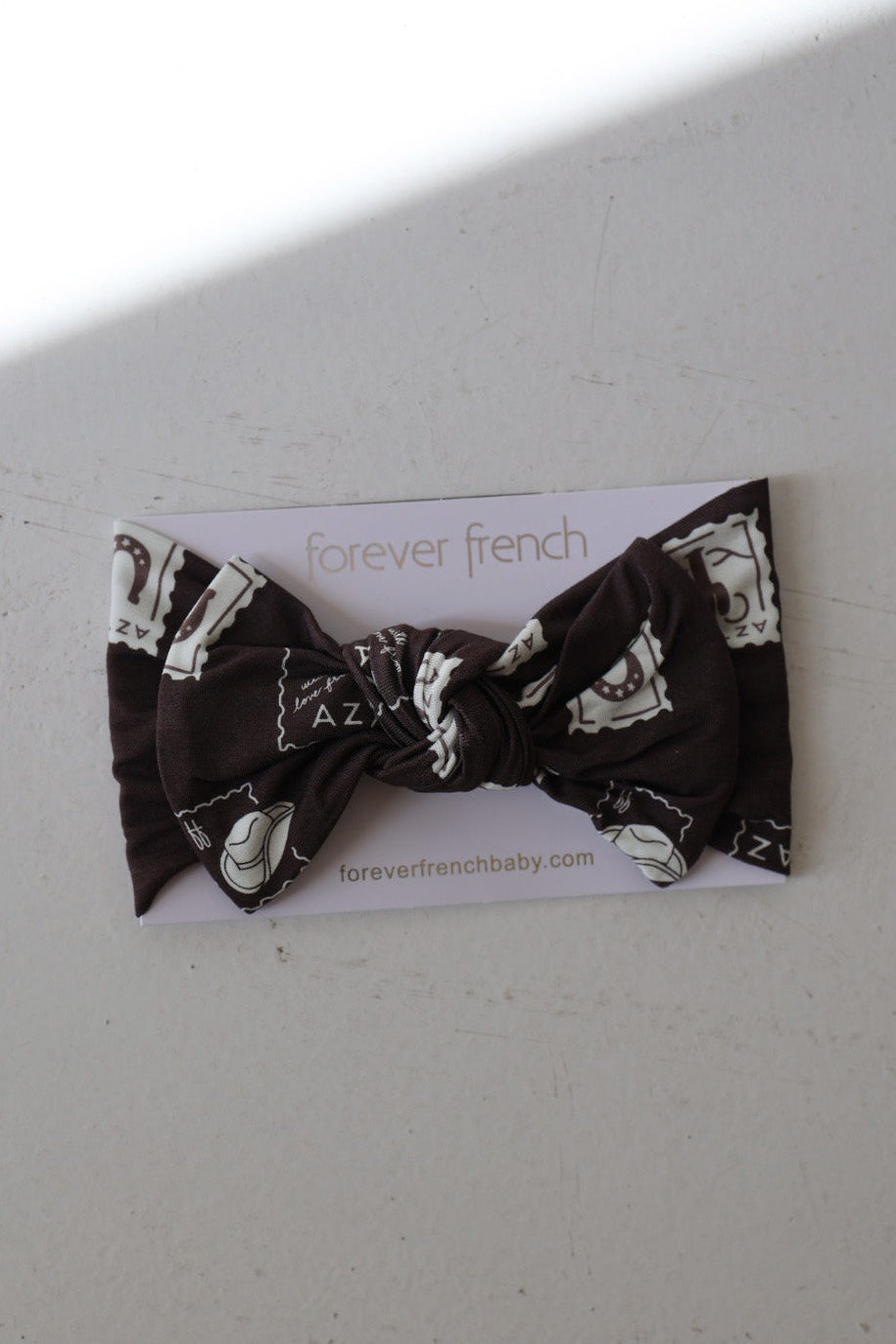 The Bamboo Head Wrap | With Love from AZ by forever french baby features black bamboo fabric with white map and letter designs, tied in a bow, and is displayed on a branded card with foreverfrenchbaby.com on a light surface.