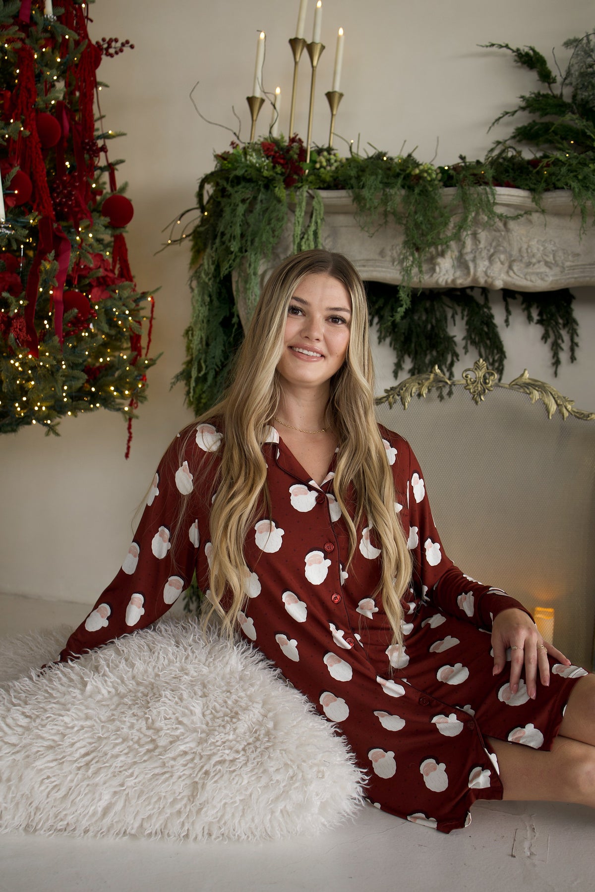 A woman wears a Women’s Bamboo Sleeping Dress | Vintage Santa, featuring a long-sleeved, button-down design with a vintage Santa pattern.
