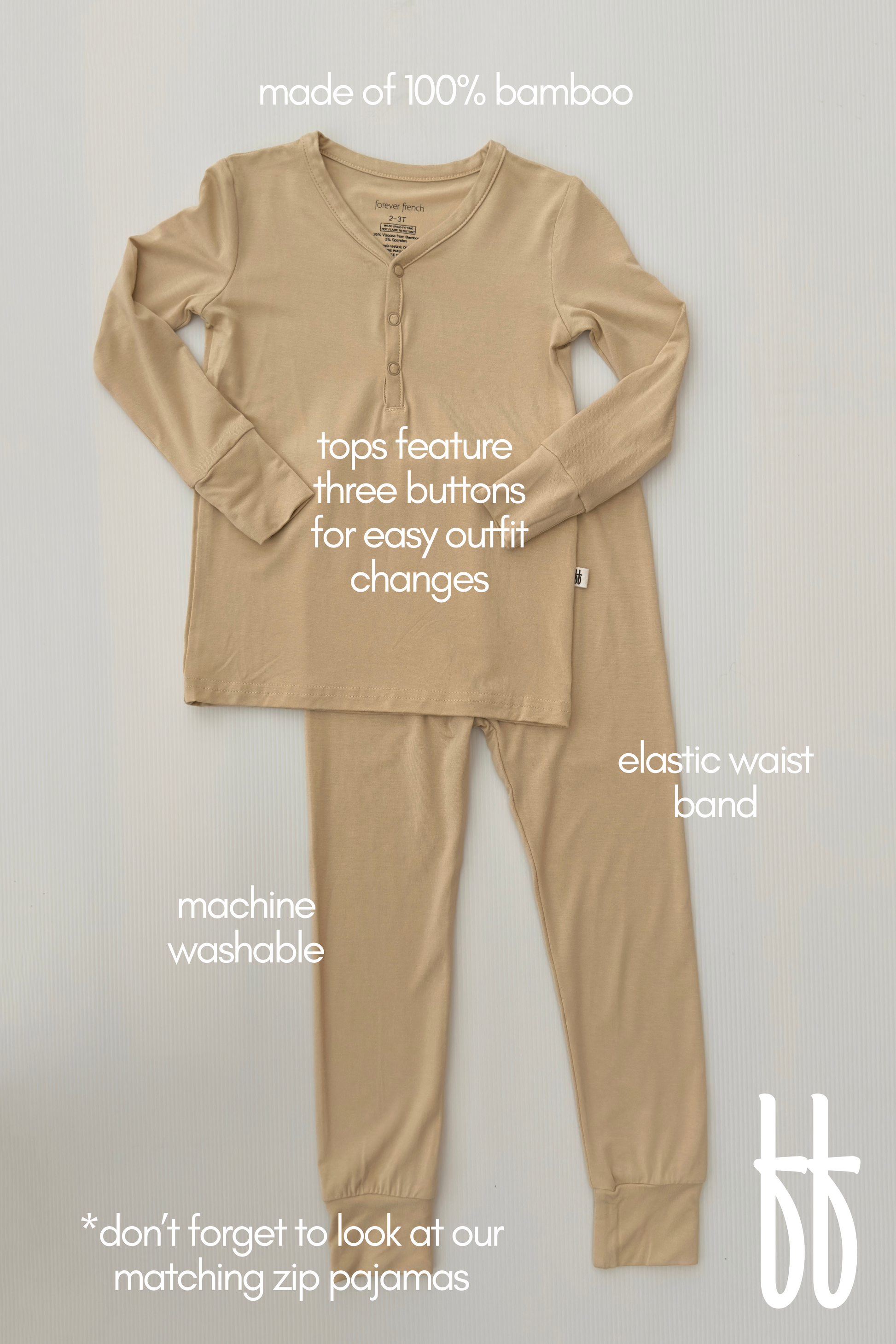 The Bamboo Two Piece Pajamas in Limestone, by forever french baby, offer breathable sleepwear for kids crafted from 100% hypo-allergenic bamboo. This set includes a long-sleeved top with three buttons and pants featuring an elastic waistband. Machine washable for easy care, it combines comfort and style while showcasing a "bb" logo at the bottom right.