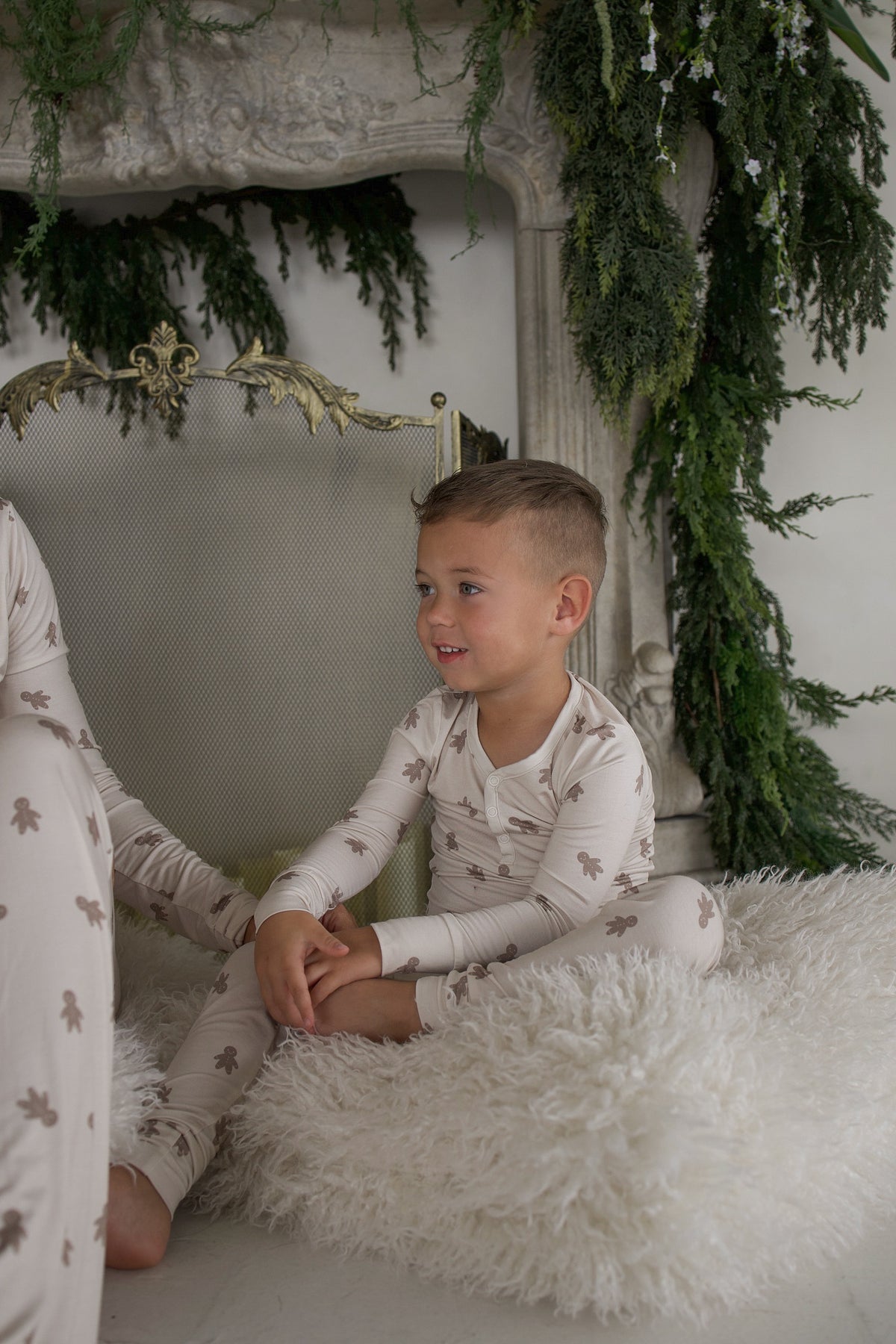 A young boy wearing Bamboo Two Piece Pajamas | Gingersnap sits on a white faux fur rug.