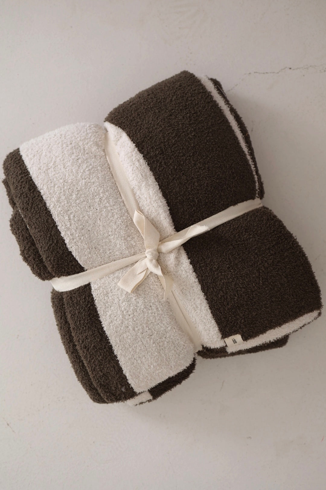 The forever french baby Plush Blanket | Fireside Stripe, featuring wide brown and white stripes, is velvety soft like your favorite blanket and Oeko-Tex certified—perfectly tied with a cream ribbon and ready for peace of mind.