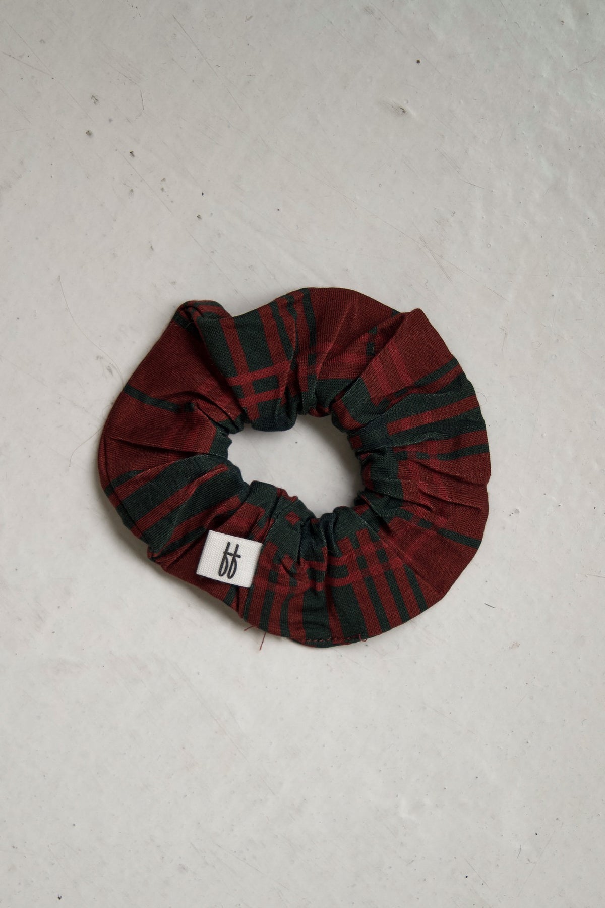 Red and green Christmas plaid bamboo Scrunchie | Christmas Plaid by forever french baby with a small white brand tag.