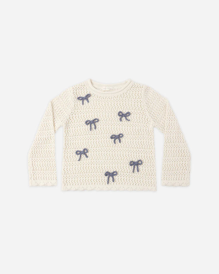 The Rylee + Cru Crochet Knit Pullover | Bows is a cream-colored, long-sleeve sweater crafted from 100% cotton, featuring a delicate crochet knit design with small blue bows embroidered across the front and a classic round neckline.