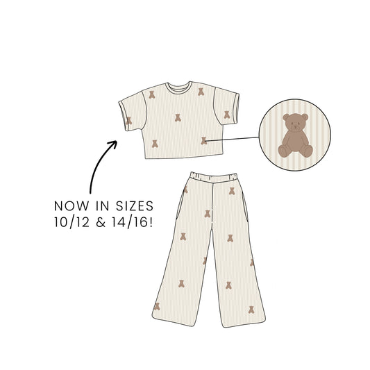 Illustration of the forever french baby Child Boxy Tee Lounge Set | Teddy in beige with a teddy bear print, short-sleeve top, and long pants. Hypo-allergenic kids’ pajamas now available in sizes 10/12 & 14/16!.
