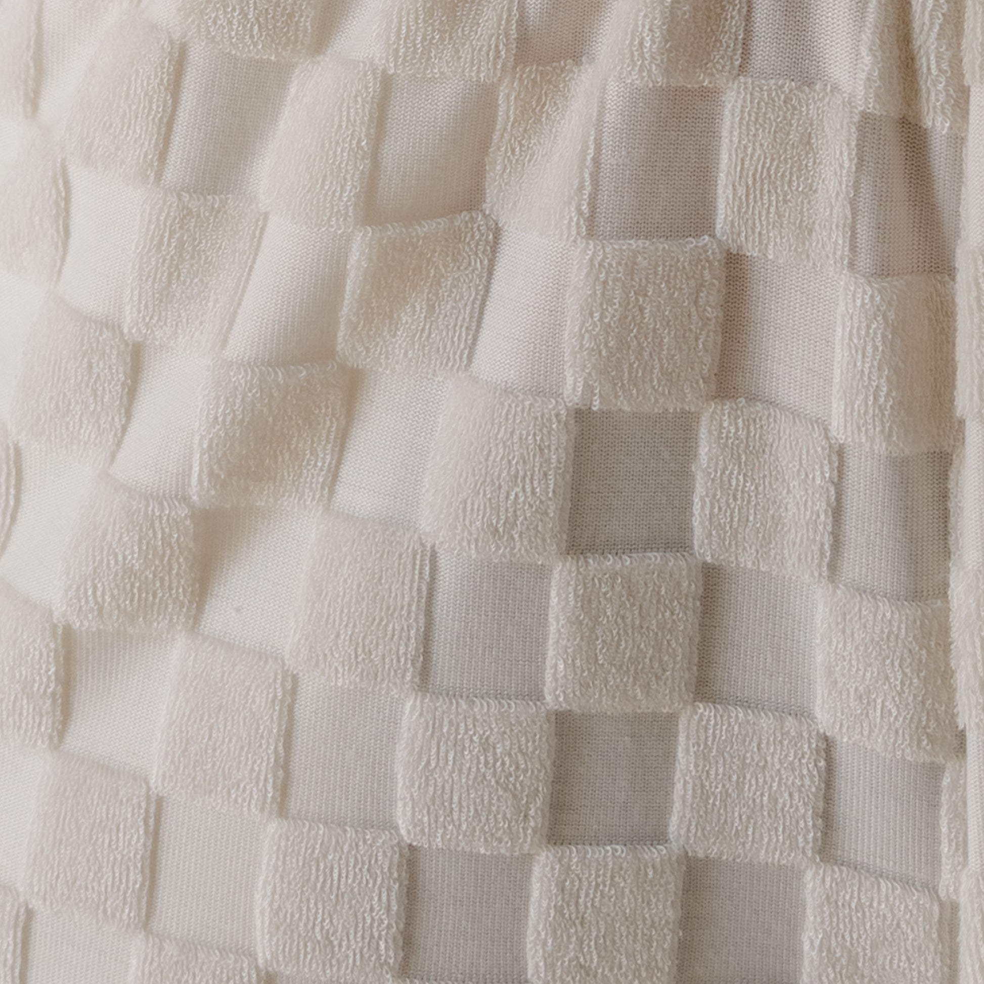 Close-up of the forever french baby Terry T-Shirt Romper in Coconut Milk, featuring a raised checkered texture with smooth and terry cloth squares—ideal for cozy, stylish outfits.