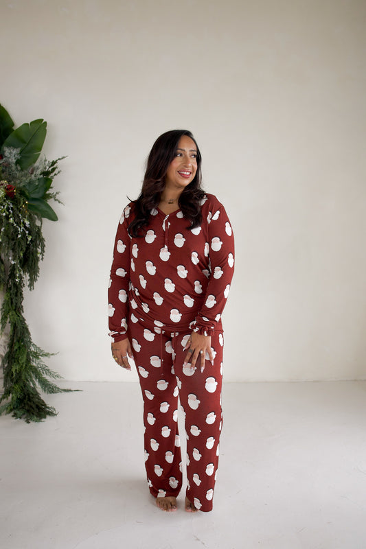 A woman wearing a maroon Women’s Long Sleeve Bamboo Pajama | Vintage Santa set featuring a white vintage Santa Claus print.